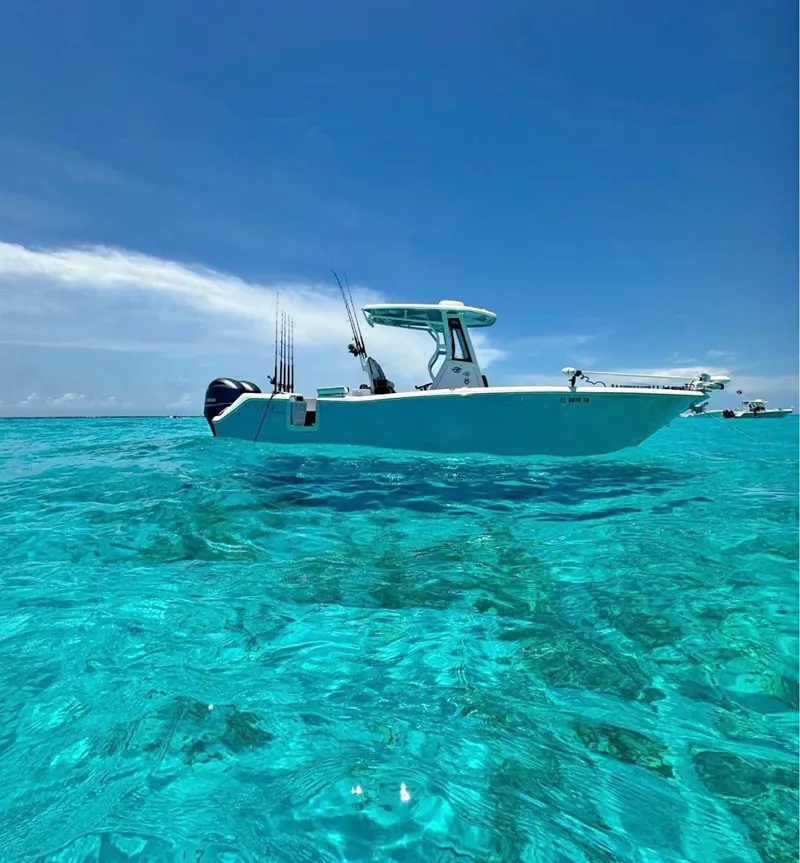 Slide: The Image of 2022 Tidewater 272 CC Adventure boat on clear turquoise water under blue sky. - 0