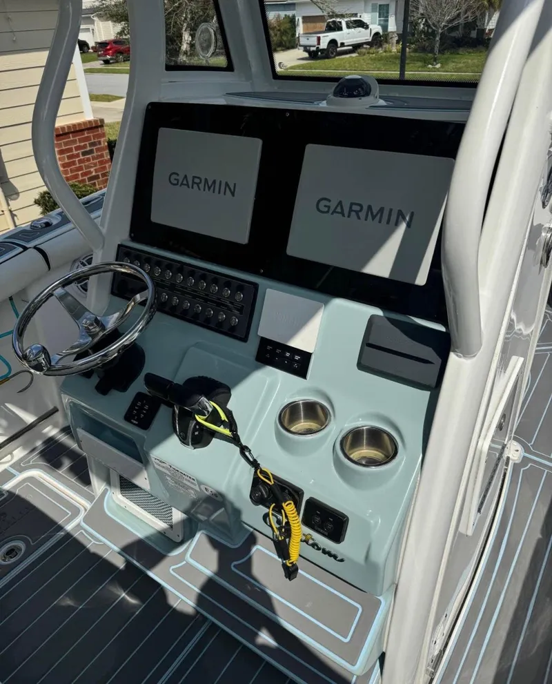 Slide: The Image of 2022 Tidewater 272 CC Adventure boat console with dual Garmin displays and steering wheel. - 2