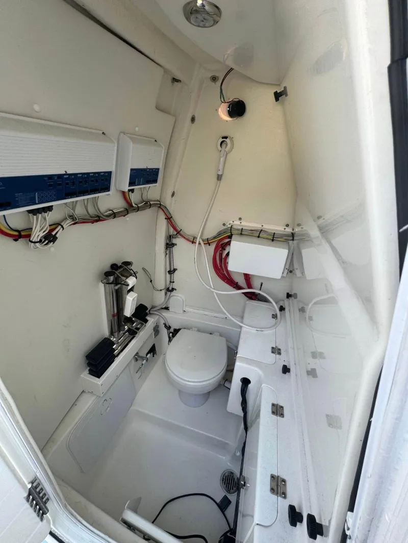 Slide: The Image of 2022 Tidewater 272 CC Adventure boat interior with compact marine toilet and storage. - 7