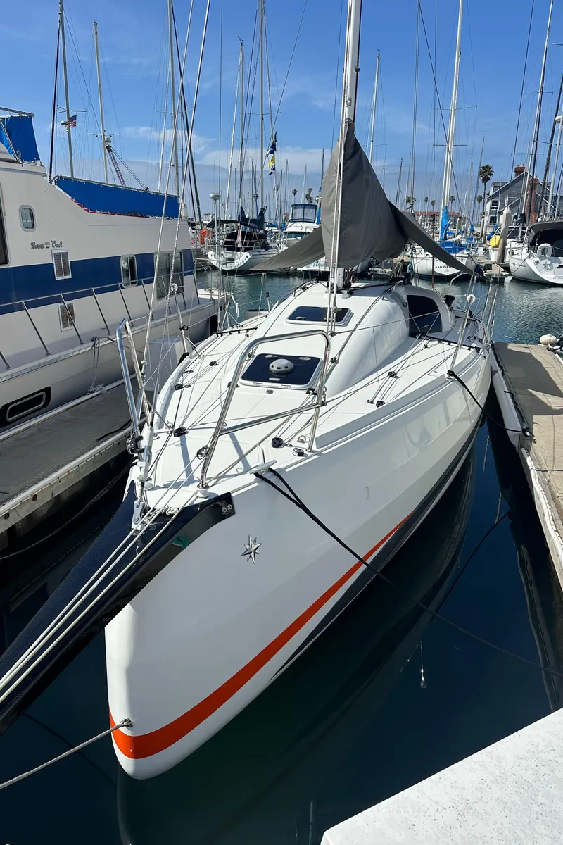 Slide: The Image of 2021 Jeanneau Sun Fast 3300 sailboat docked in marina, clear sky background. - 1