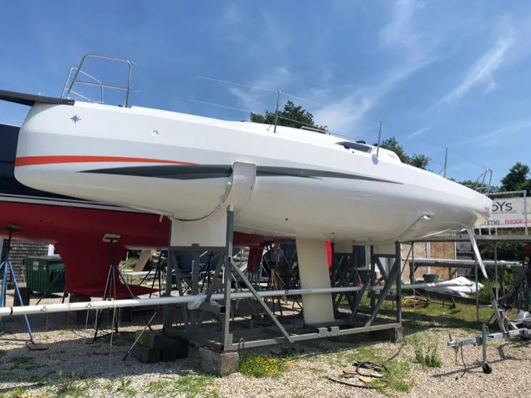 Slide: The Image of 2021 Jeanneau SUNFAST 3300 sailboat on dry dock under clear blue sky. - 13