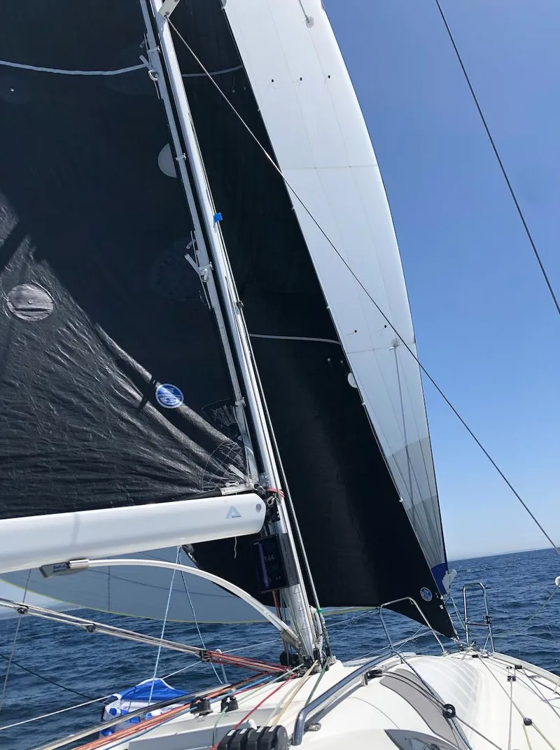 Slide: The Image of 2021 Jeanneau SUNFAST 3300 sailboat with black sails on open water. - 14