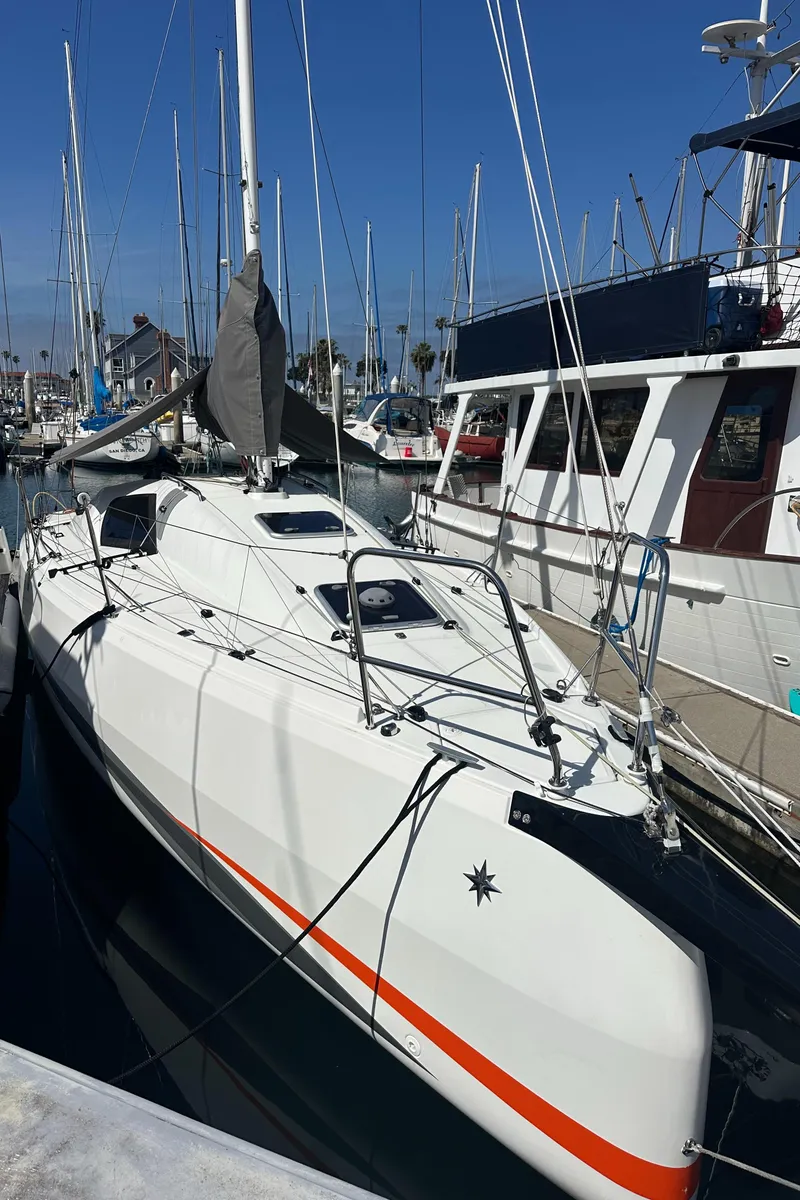 Slide: The Image of 2021 Jeanneau Sun Fast 3300 sailboat docked in marina under clear blue sky. - 2