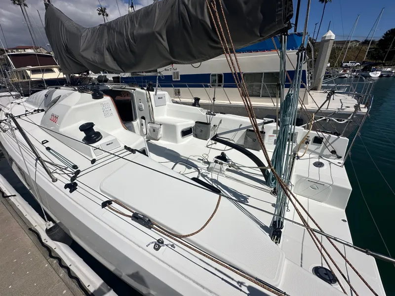 Slide: The Image of 2021 Jeanneau Sun Fast 3300 sailboat docked at marina, showcasing sleek deck design. - 3