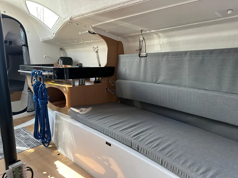 Slide: The Image of Interior of 2021 Jeanneau Sun Fast 3300 sailboat with gray seating and wooden accents. - 42