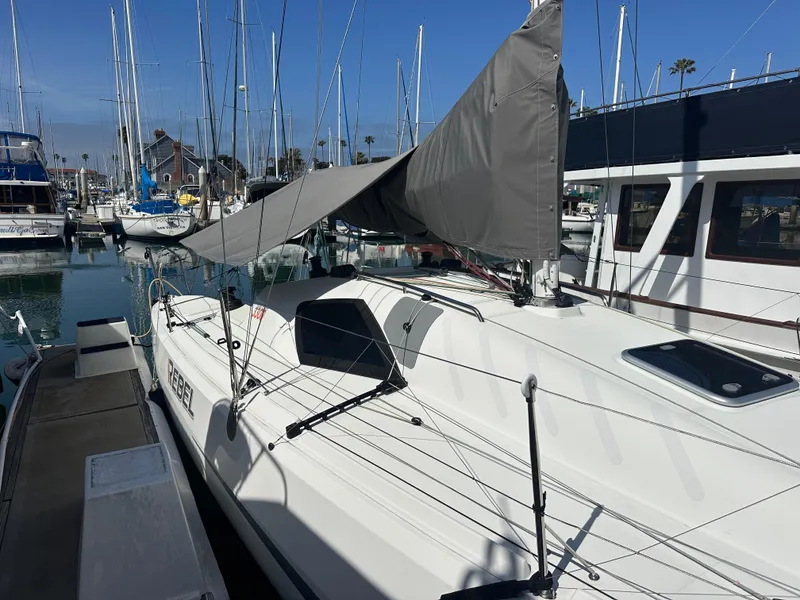 Slide: The Image of 2021 Jeanneau Sun Fast 3300 sailboat docked in marina, sails partially raised. - 44