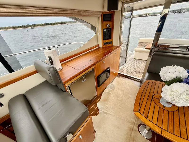 Slide: The Image of 2007 Riviera 3600 Sport Yacht interior with elegant wood finish and waterfront view. - 12