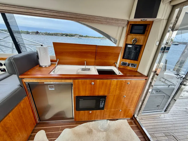 Slide: The Image of 2007 Riviera 3600 Sport Yacht interior kitchen with wood cabinetry, sink, and appliances. - 13