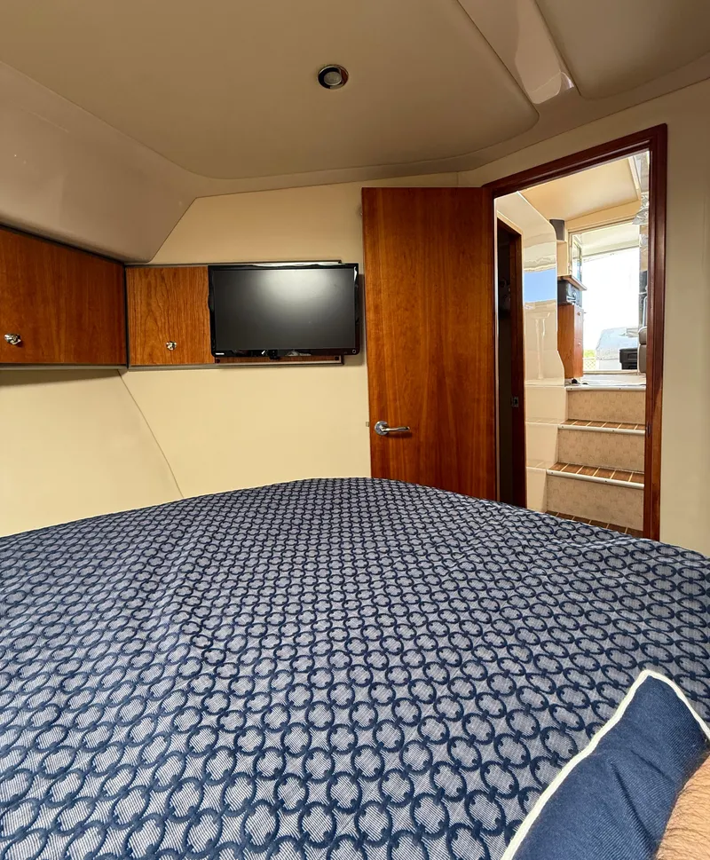 Slide: The Image of 2007 Riviera 3600 Sport Yacht cabin with bed, TV, and wooden interior. - 19