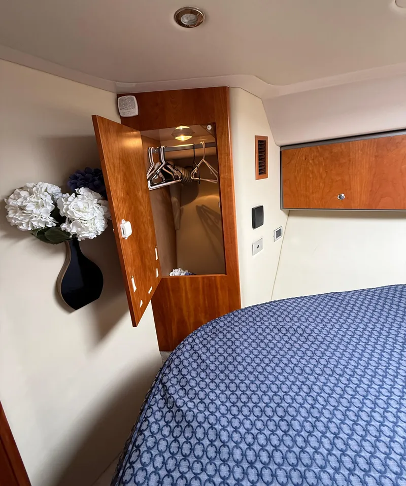 Slide: The Image of 2007 Riviera 3600 Sport Yacht cabin with closet, floral decor, and patterned bedding. - 21