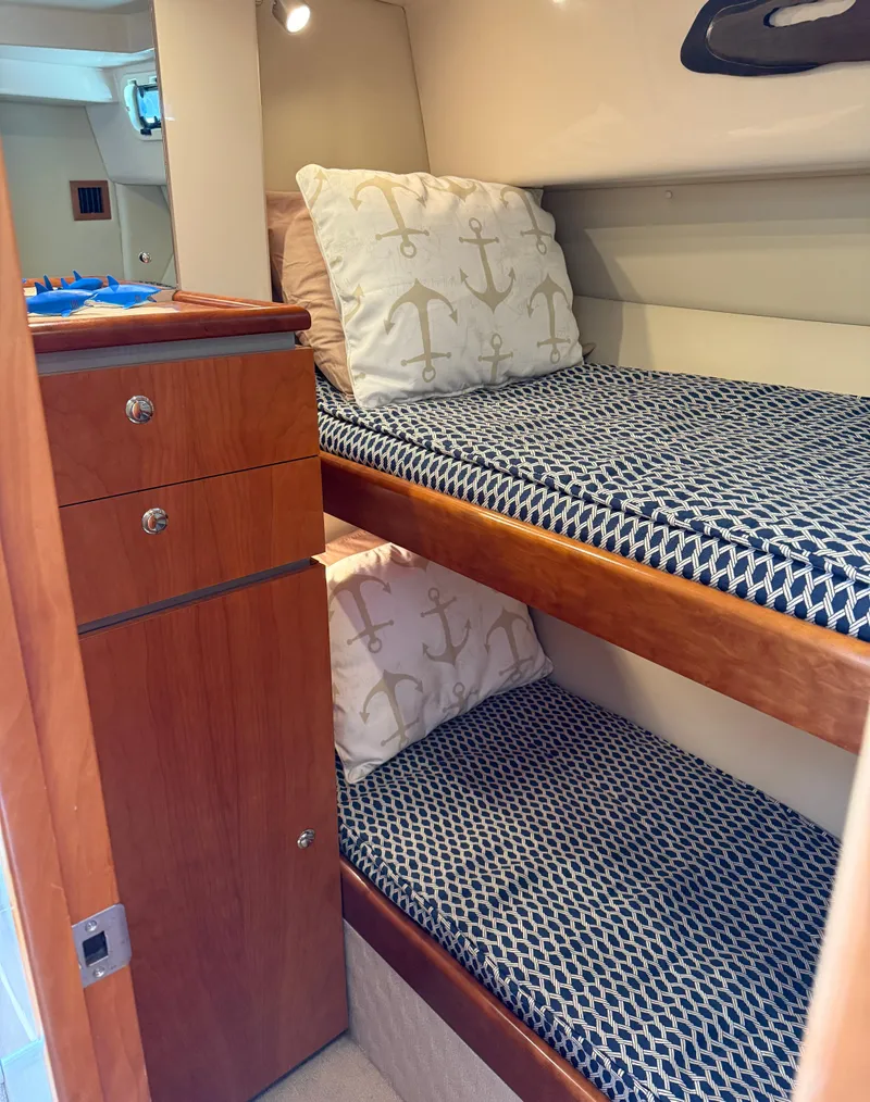 Slide: The Image of 2007 Riviera 3600 Sport Yacht cabin with bunk beds and nautical-themed pillows. - 24