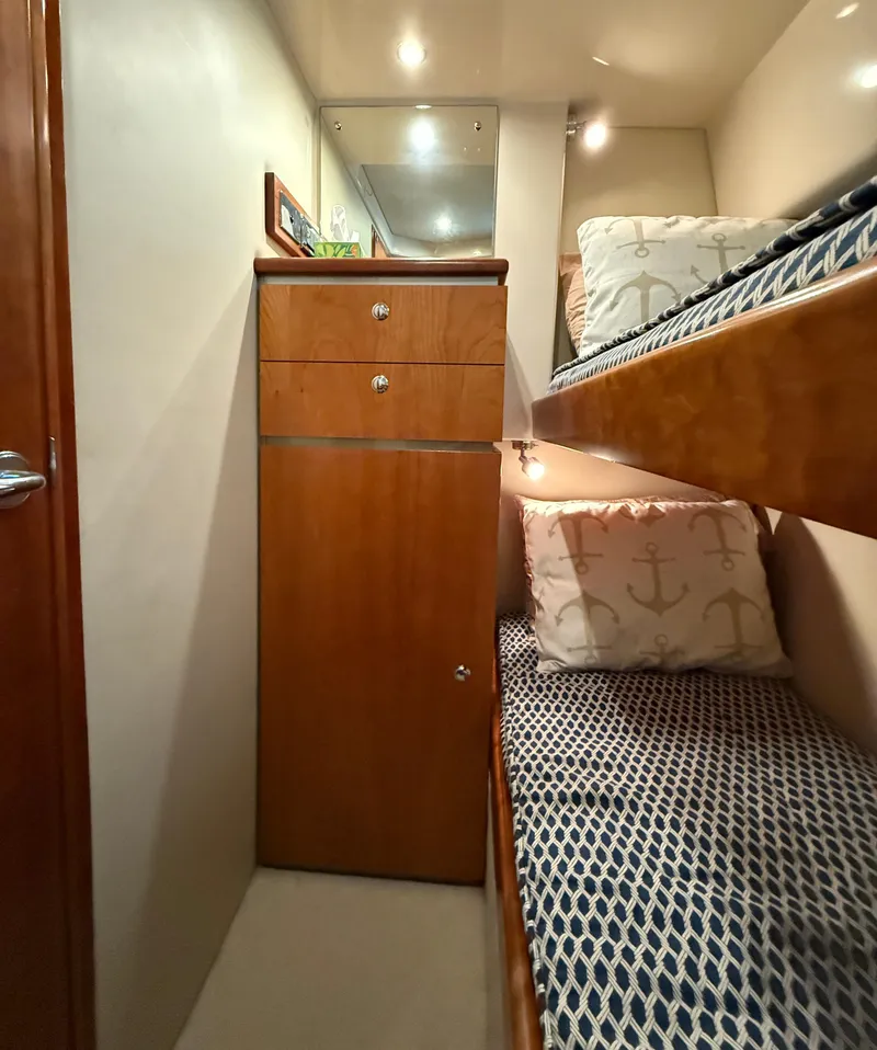 Slide: The Image of Interior of 2007 Riviera 3600 Sport Yacht with cozy bunk beds and wooden cabinetry. - 25