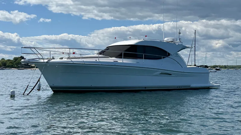 Slide: The Image of 2007 Riviera 3600 Sport Yacht on calm water under a partly cloudy sky. - 3