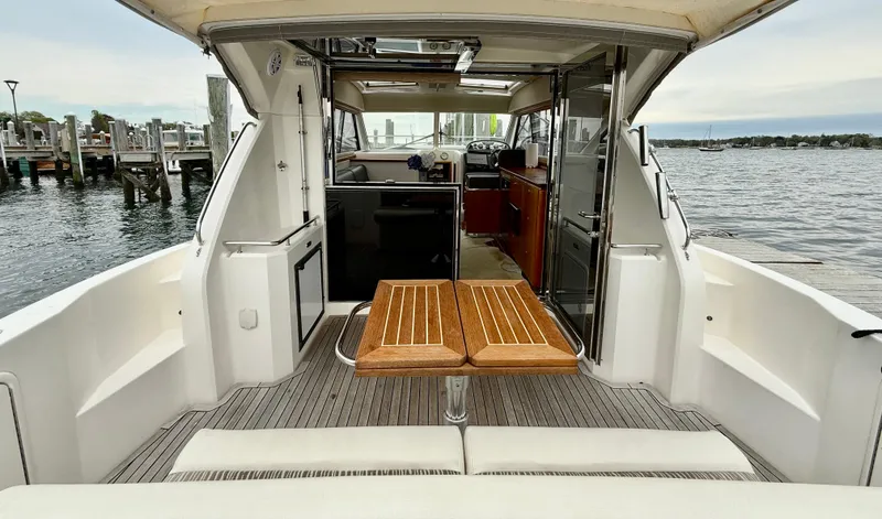 Slide: The Image of 2007 Riviera 3600 Sport Yacht interior with wooden table, docked by the water. - 8