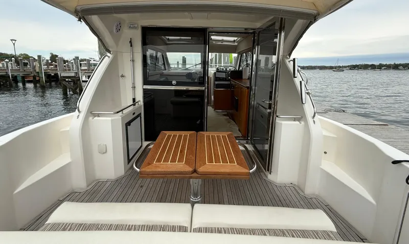 Slide: The Image of 2007 Riviera 3600 Sport Yacht with open deck, wooden table, and marina view. - 9