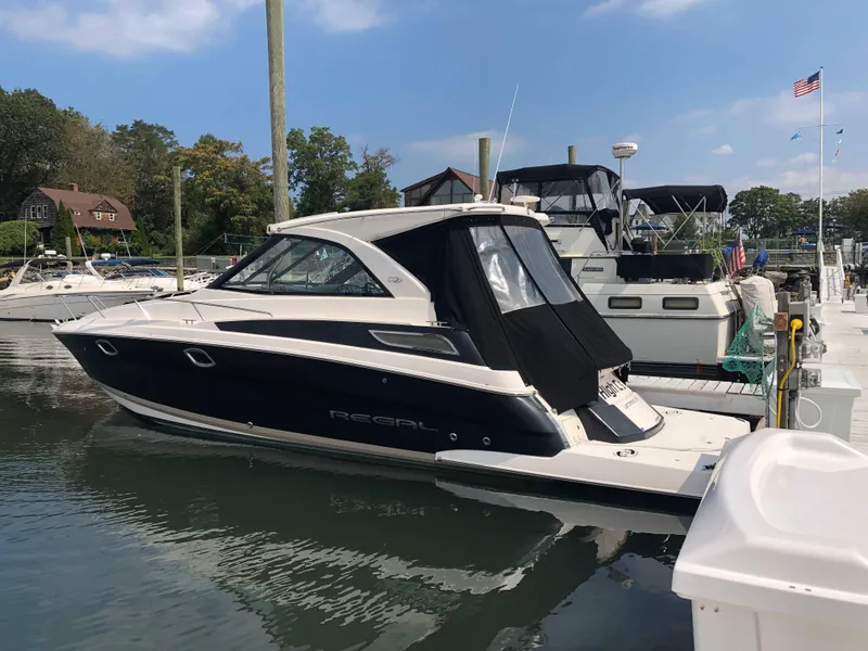 Slide: The Image of 2012 Regal 35 Sport Coupe docked at marina under clear sky. - 0
