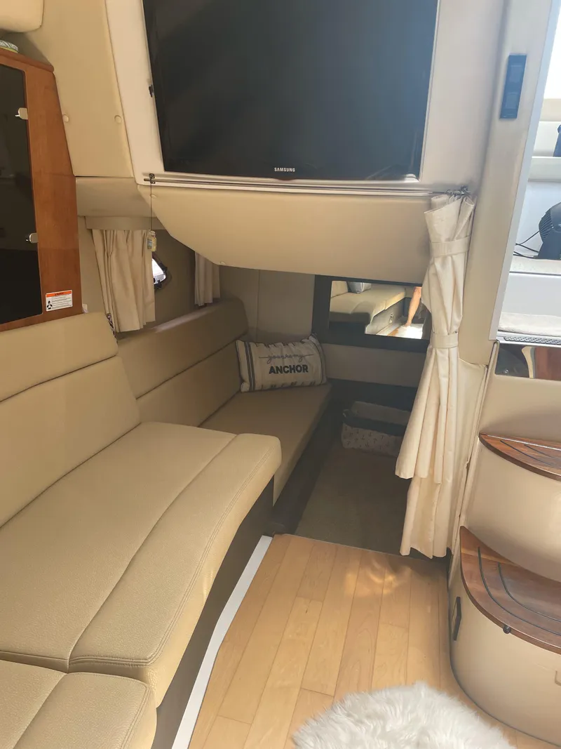 Slide: The Image of Interior of a 2012 Regal 35 Sport Coupe with beige seating and a mounted TV. - 10