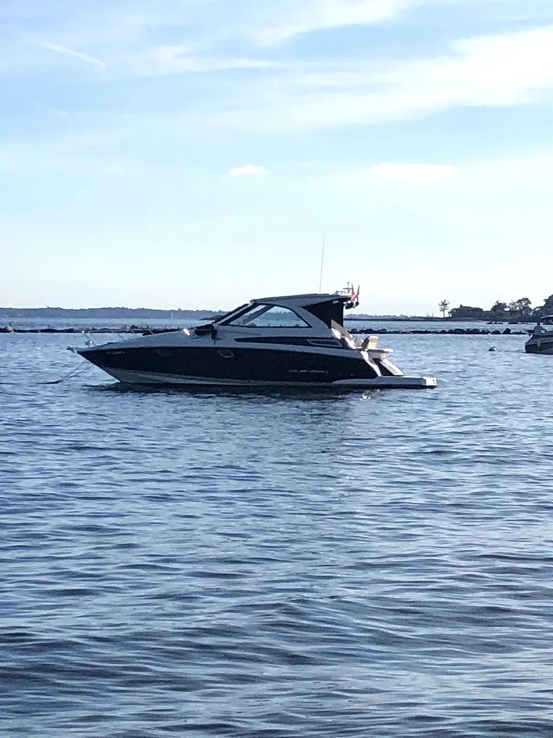 Slide: The Image of 2012 Regal 35 Sport Coupe boat on calm water under a clear sky. - 2