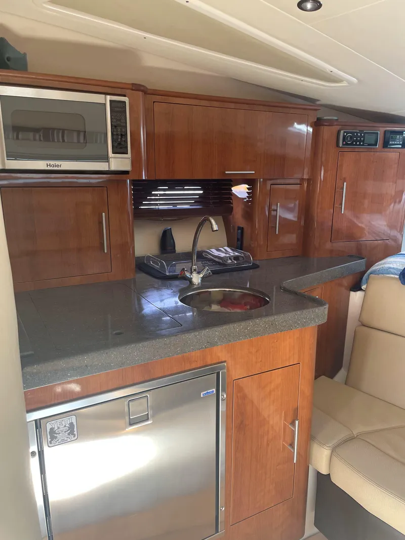 Slide: The Image of 2012 Regal 35 Sport Coupe interior kitchen with wood cabinets and modern appliances. - 26