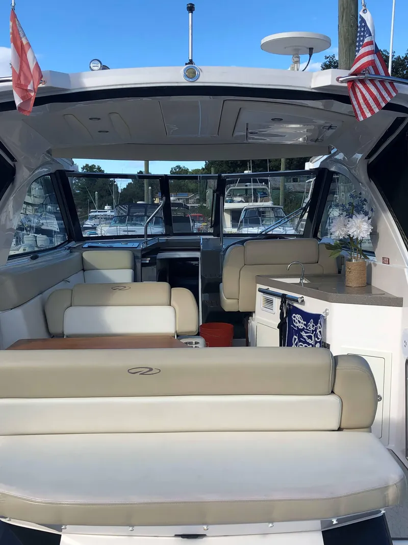 Slide: The Image of 2012 Regal 35 Sport Coupe interior with seating, flags, and marina view. - 5