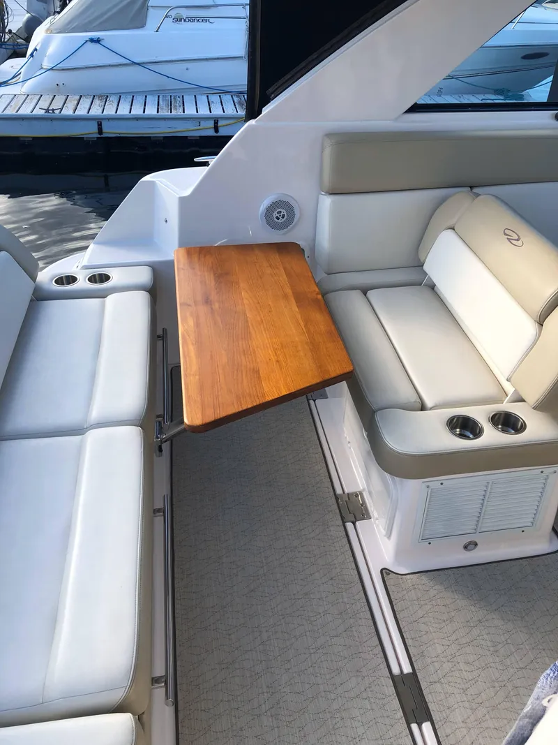 Slide: The Image of 2012 Regal 35 Sport Coupe interior with white seating and wooden table. - 7