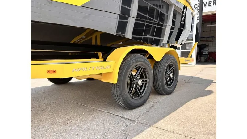 Slide: The Image of 2023 Nautique Super Air Nautique S21 trailer with yellow accents and black wheels. - 10