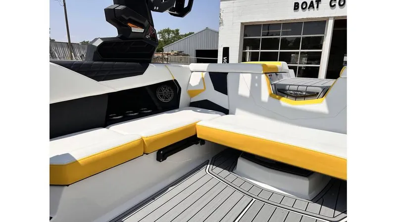 Slide: The Image of 2023 Nautique Super Air Nautique S21 interior with yellow and white seating, near a boat company. - 22