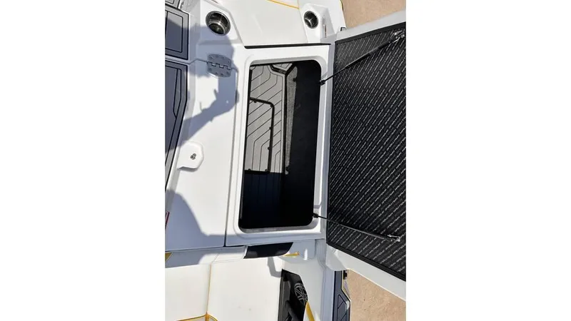 Slide: The Image of 2023 Nautique Super Air Nautique S21 storage compartment, open hatch, white and black interior. - 24