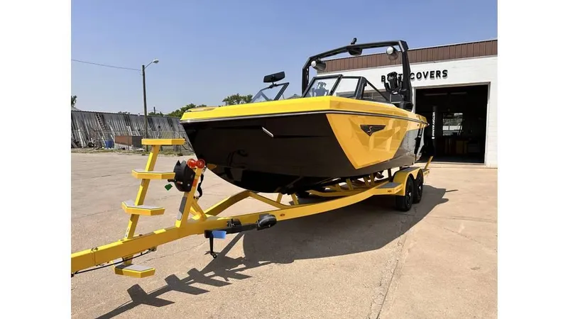 Slide: The Image of 2023 Nautique Super Air Nautique S21 boat in yellow on trailer outside a building. - 3