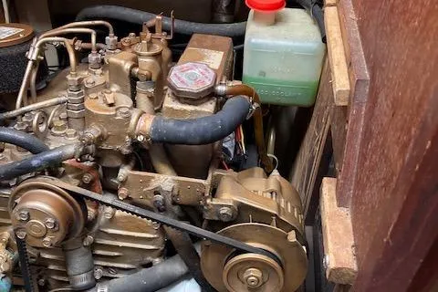 Slide: The Image of Engine compartment of a 1988 Catalina 34 sailboat, featuring mechanical components and coolant reservoir. - 11