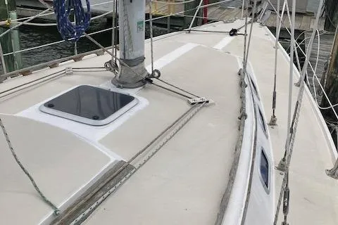 Slide: The Image of 1988 Catalina 34 sailboat deck with rigging and hatch, docked at marina. - 2