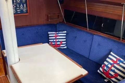 Slide: The Image of Interior of 1988 Catalina 34 sailboat with blue seating and nautical-themed pillows. - 4