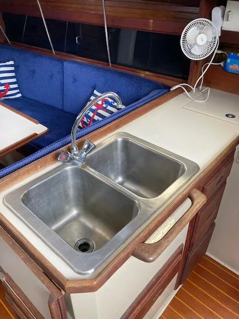 Slide: The Image of 1988 Catalina 34 yacht interior with dual sink, wooden cabinetry, and blue seating. - 5
