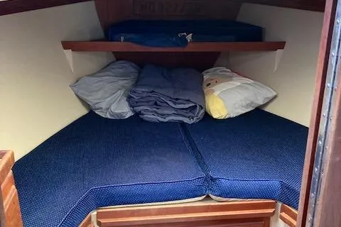Slide: The Image of Cozy sleeping area in a 1988 Catalina 34 sailboat with blue cushions and pillows. - 8