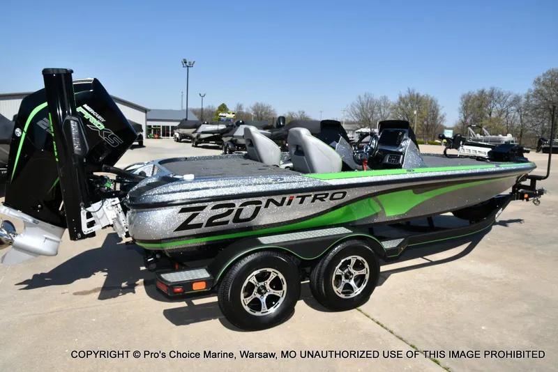 Slide: The Image of 2021 Nitro Z20 Pro Pack boat with green accents on a trailer in a parking lot. - 19