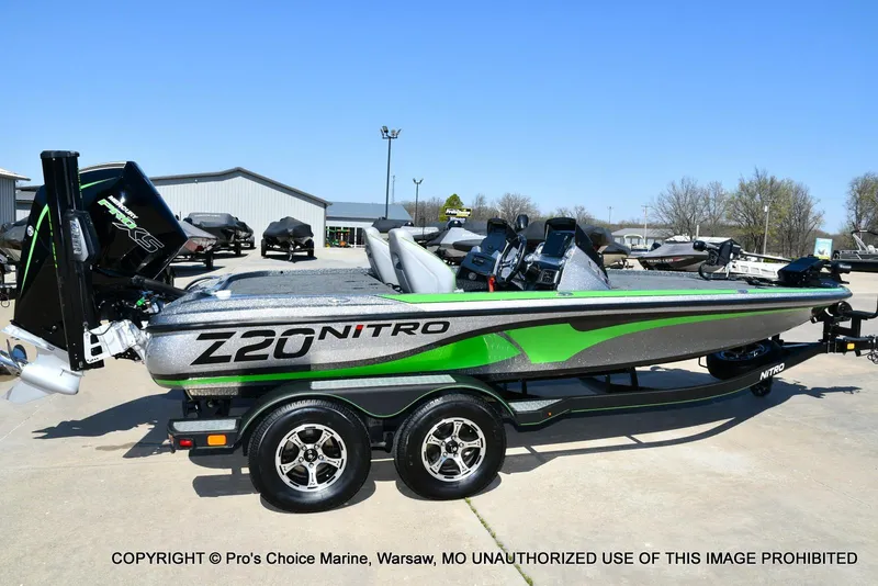 Slide: The Image of 2021 Nitro Z20 Pro Pack boat with green accents on a trailer in a marina. - 20
