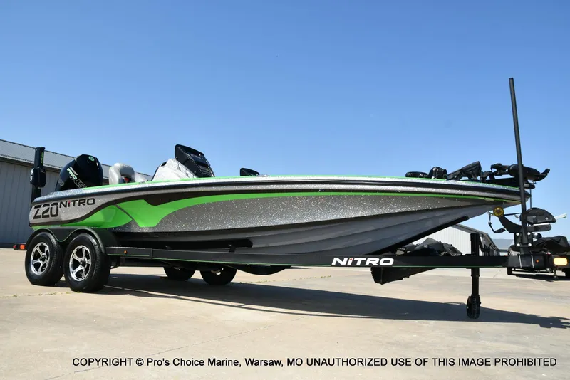 Slide: The Image of 2021 Nitro Z20 Pro Pack boat on trailer, green and silver design, clear blue sky background. - 8