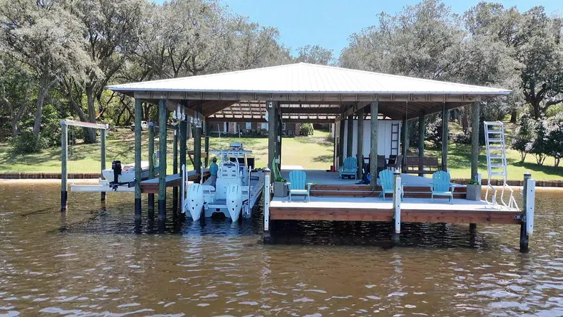 Slide: The Image of Covered dock with Costa Custom Boats 264 HC, 2022 model, surrounded by trees and water. - 20