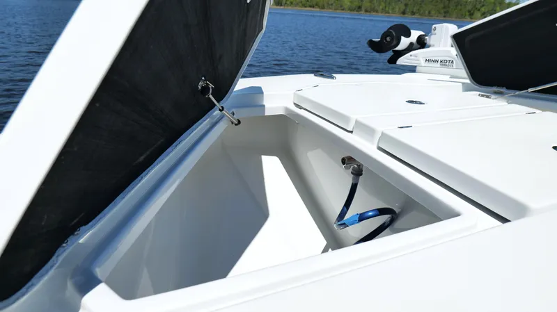 Slide: The Image of Open storage compartment on 2022 Costa Custom Boats 264 HC, with scenic water backdrop. - 29