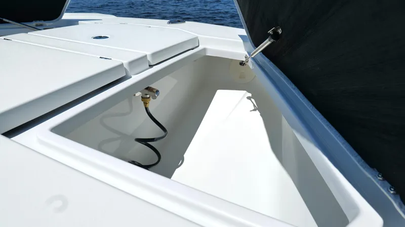 Slide: The Image of 2022 Costa Custom Boats 264 HC storage compartment with hose, open on the deck. - 31