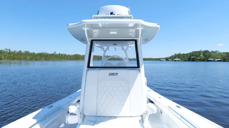 Slide: The Image of 2022 Costa Custom Boats 264 HC on serene lake with clear blue sky. - 37