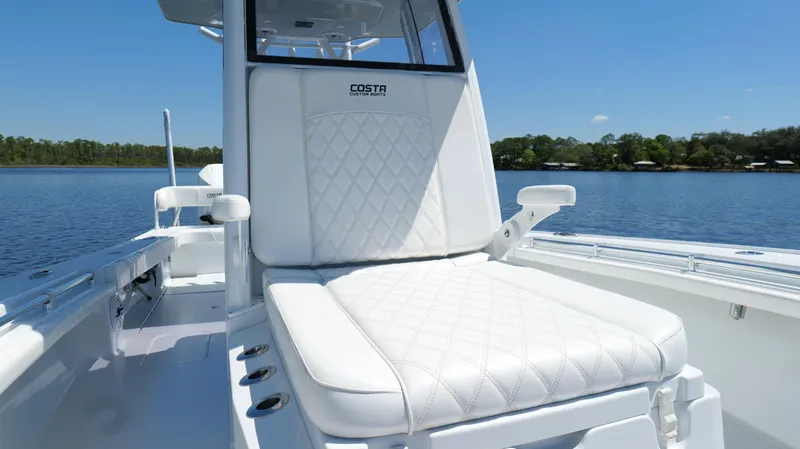 Slide: The Image of 2022 Costa Custom Boats 264 HC with white seating, on a serene lake backdrop. - 41