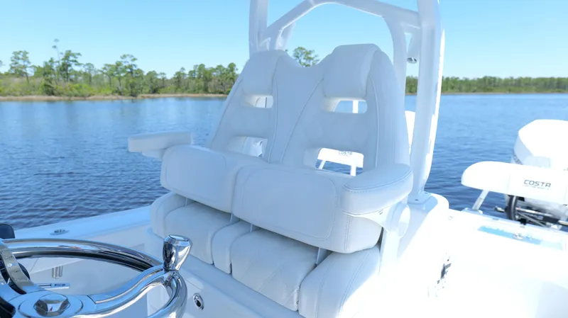 Slide: The Image of 2022 Costa Custom Boats 264 HC helm seats on a serene water backdrop. - 48