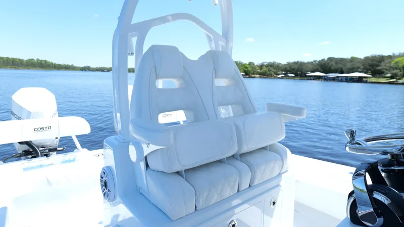 Slide: The Image of 2022 Costa Custom Boats 264 HC with plush seating on a serene lake. - 49