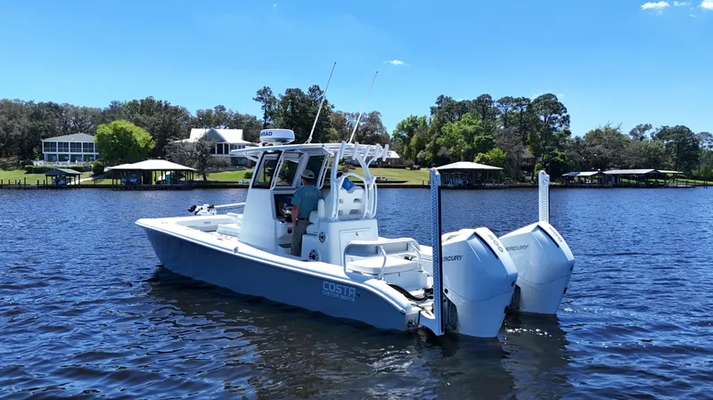 Slide: The Image of 2022 Costa Custom Boats 264 HC on a serene lake with clear blue skies. - 5