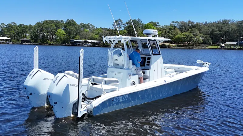 Slide: The Image of 2022 Costa Custom Boats 264 HC on a serene lake with dual Mercury engines. - 7