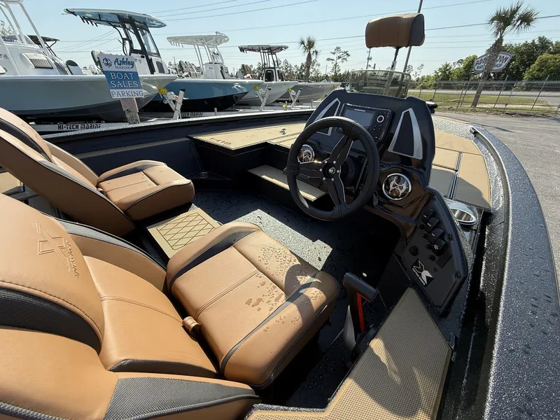 Slide: The Image of 2025 Xpress Hyper-Lift Series H18 bass boat interior with tan seats and modern dashboard. - 4