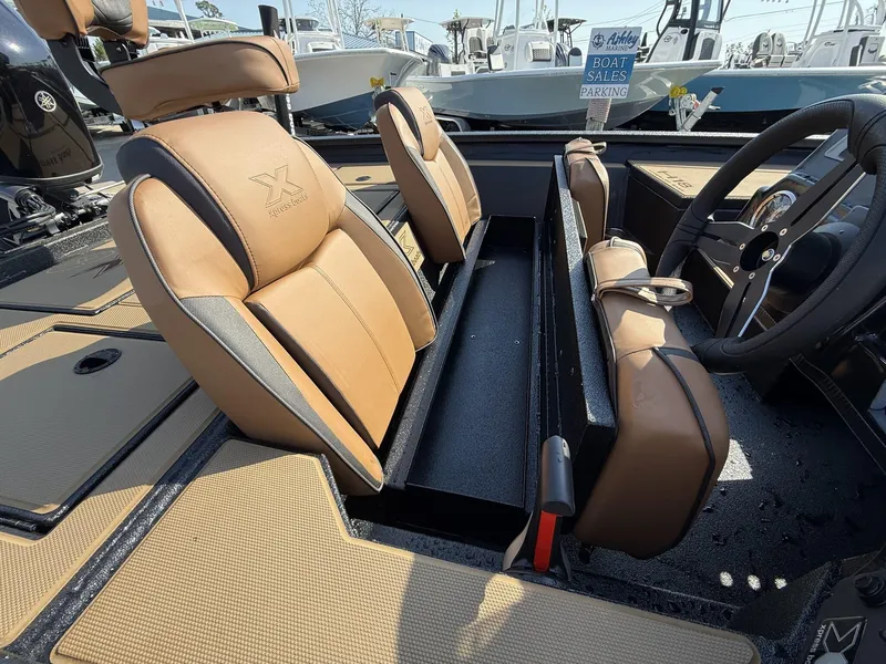 Slide: The Image of 2025 Xpress Hyper-Lift Series H18 bass boat interior with tan seats and steering wheel. - 5