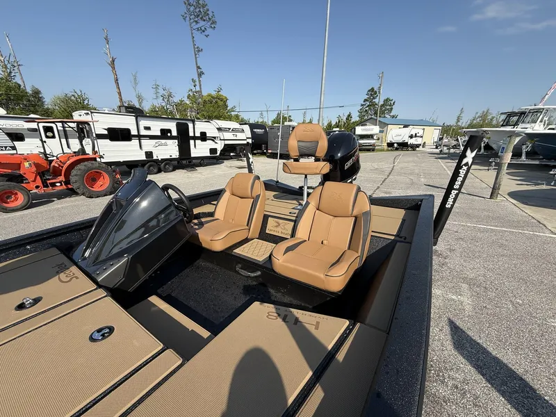Slide: The Image of 2025 Xpress Hyper-Lift Series H18 bass boat with tan seats in a parking lot. - 8