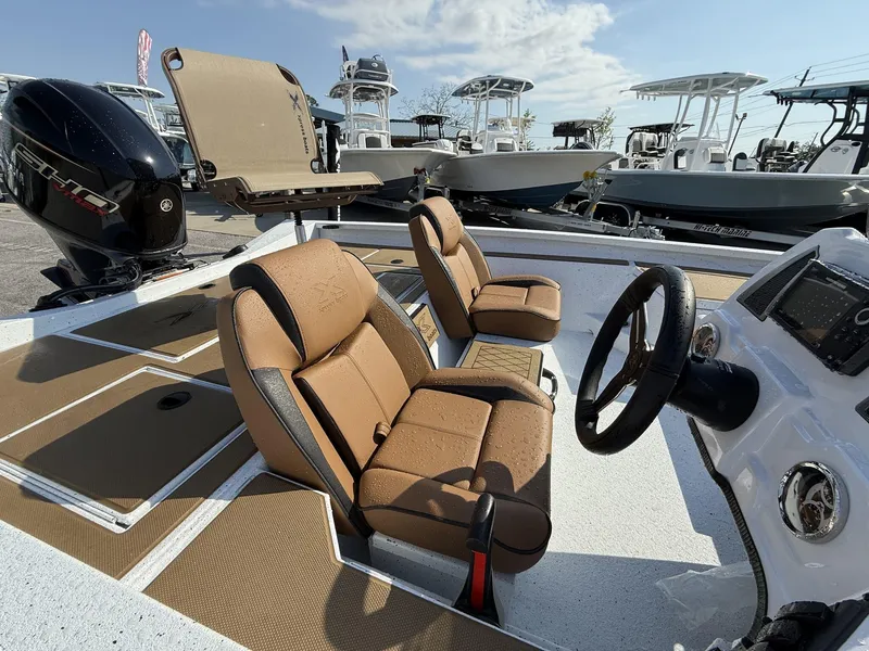 Slide: The Image of 2025 Xpress Hyper-Lift H18 Crappie boat interior with tan seats and steering console. - 7